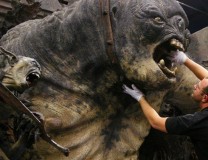 A man works on the exhibit "Cave Troll"